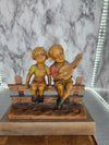 Antique Vintage Resin Statue of a Boy and Girl singing on a fence